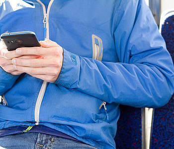 Mann mit Smartphone im Bus